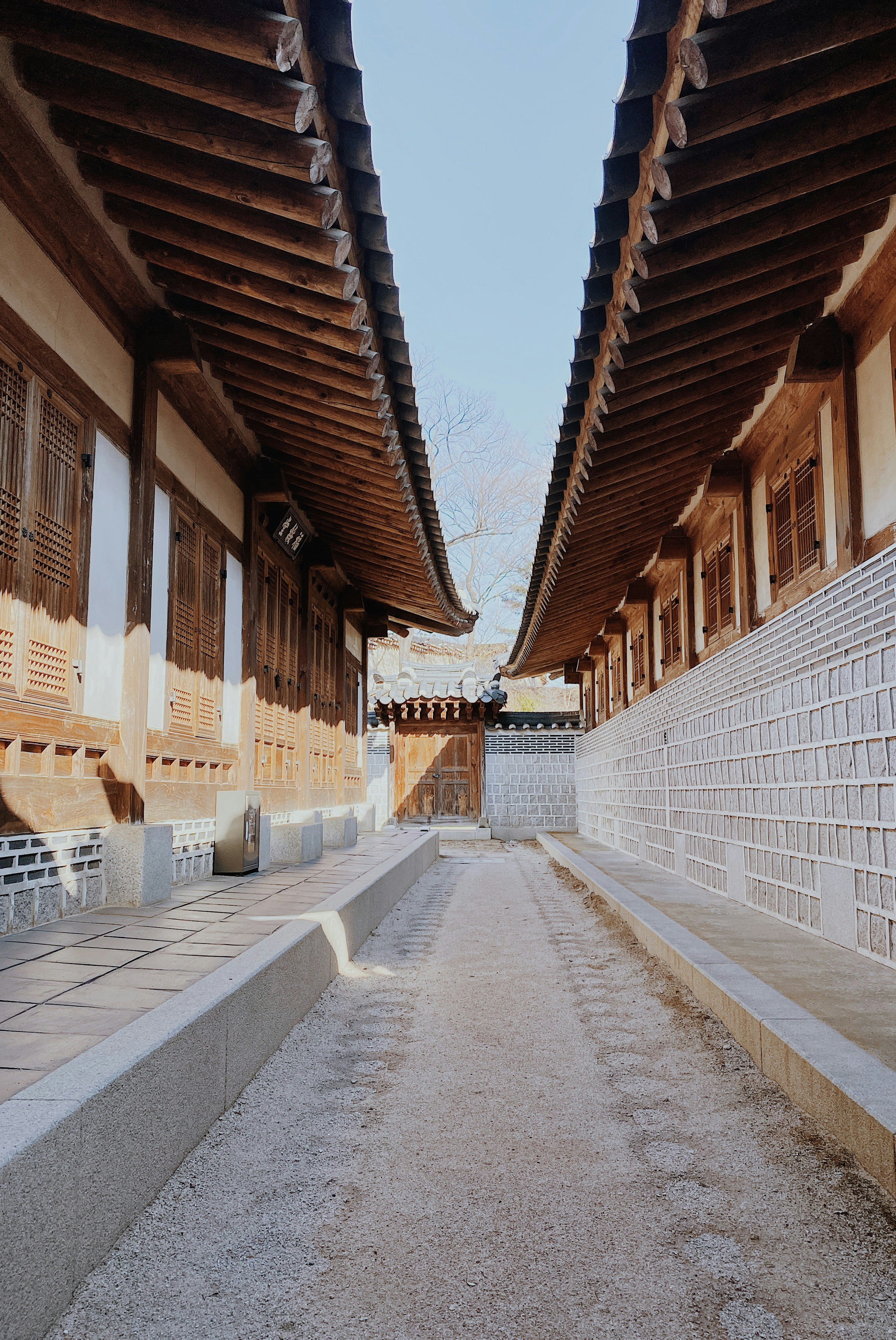 a walkway between two buildings with a sky background