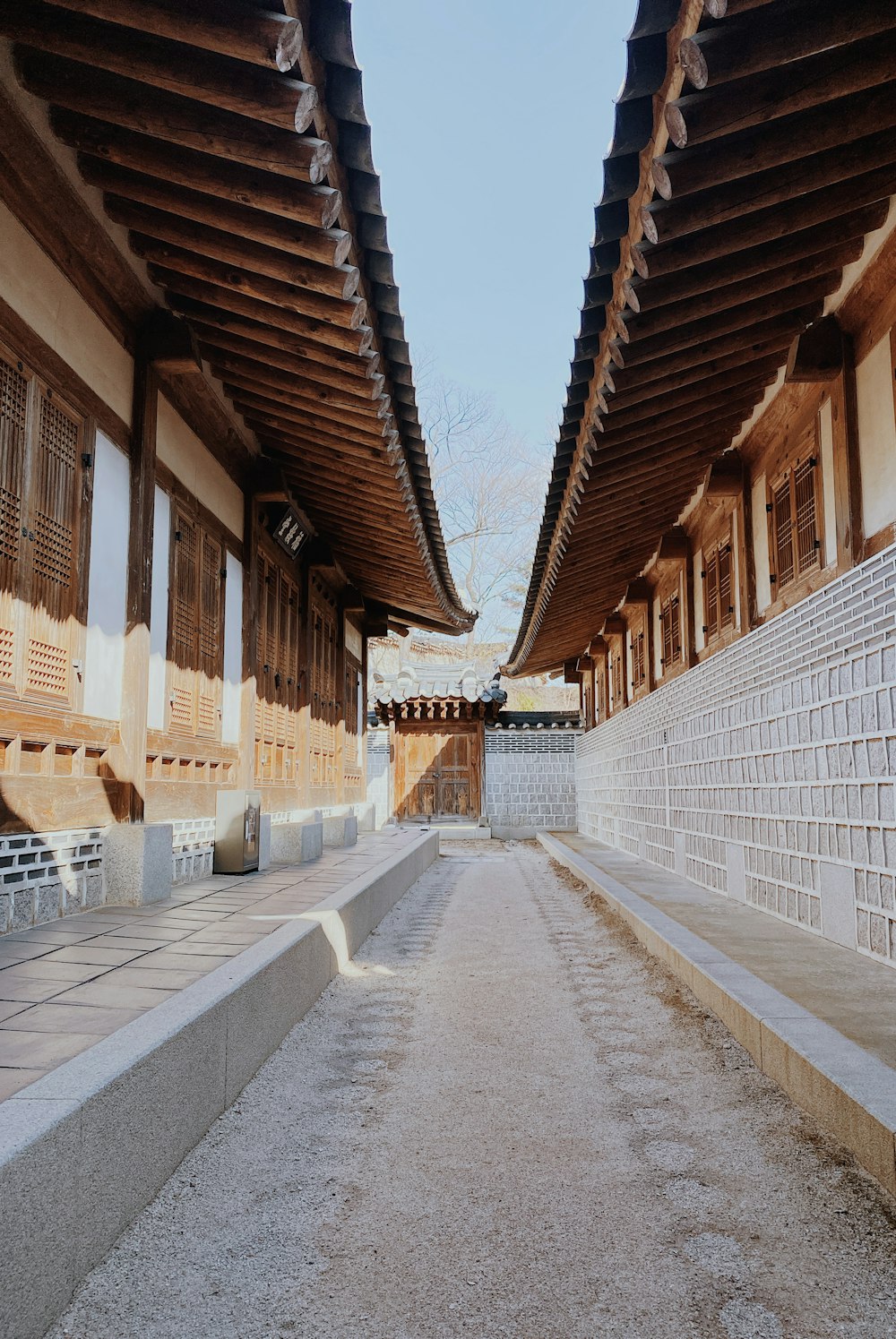 a walkway between two buildings with a sky background