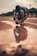 man in black t-shirt and orange pants doing yoga on brown sand during daytime