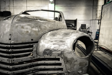 A vintage car mid-restoration with fresh paint and polished chrome.