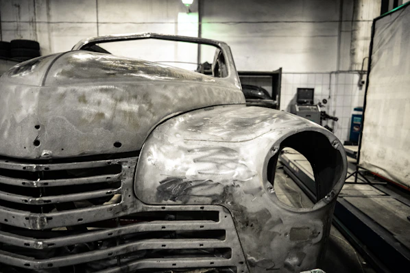 Close-up shot of an artisan carefully layering fiberglass in a vintage car body mold.