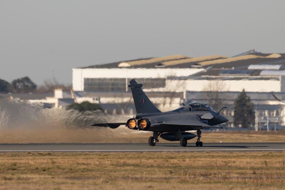 black fighter jet on brown field during daytime