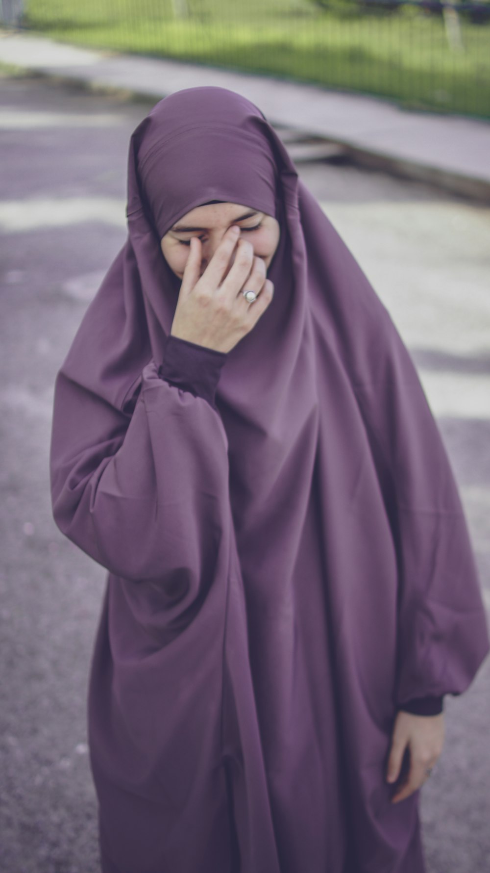 woman in purple hijab covering her face with purple textile