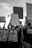A black and white photograph of a protest where individuals are holding signs with messages advocating for justice, referencing George Floyd and against police brutality. People are wearing masks and appear to be in motion, raising signs that convey messages of activism and solidarity.