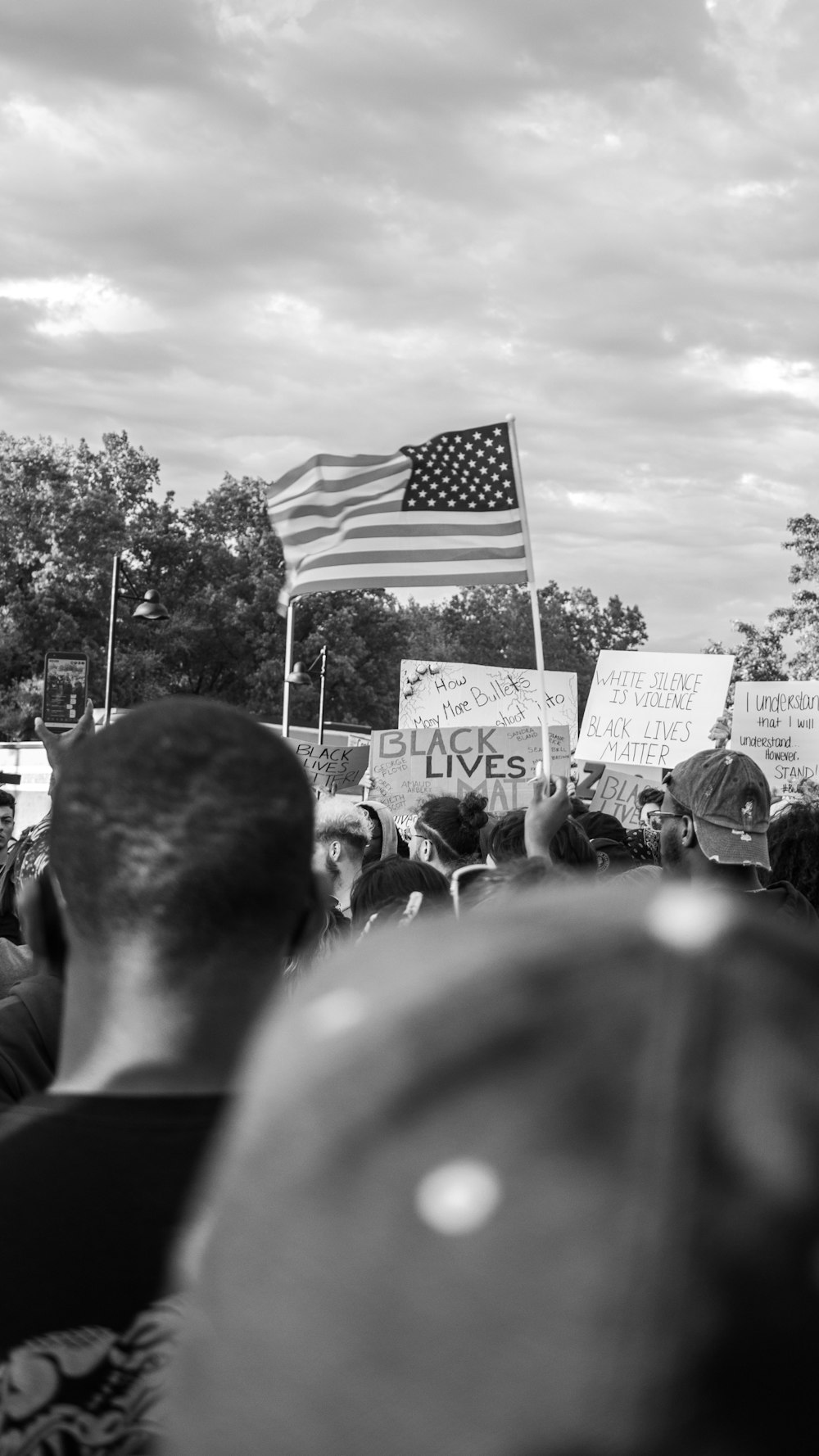 grayscale photo of people holding flag of us a during daytime