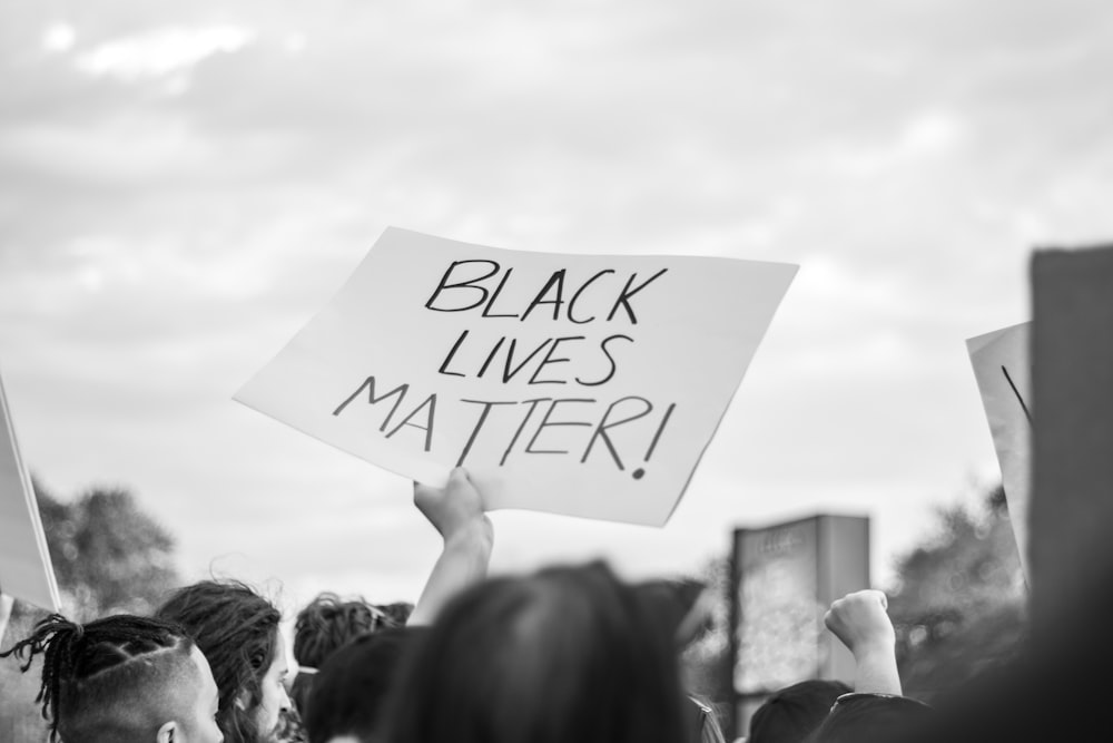 grayscale photo of people holding white printer paper