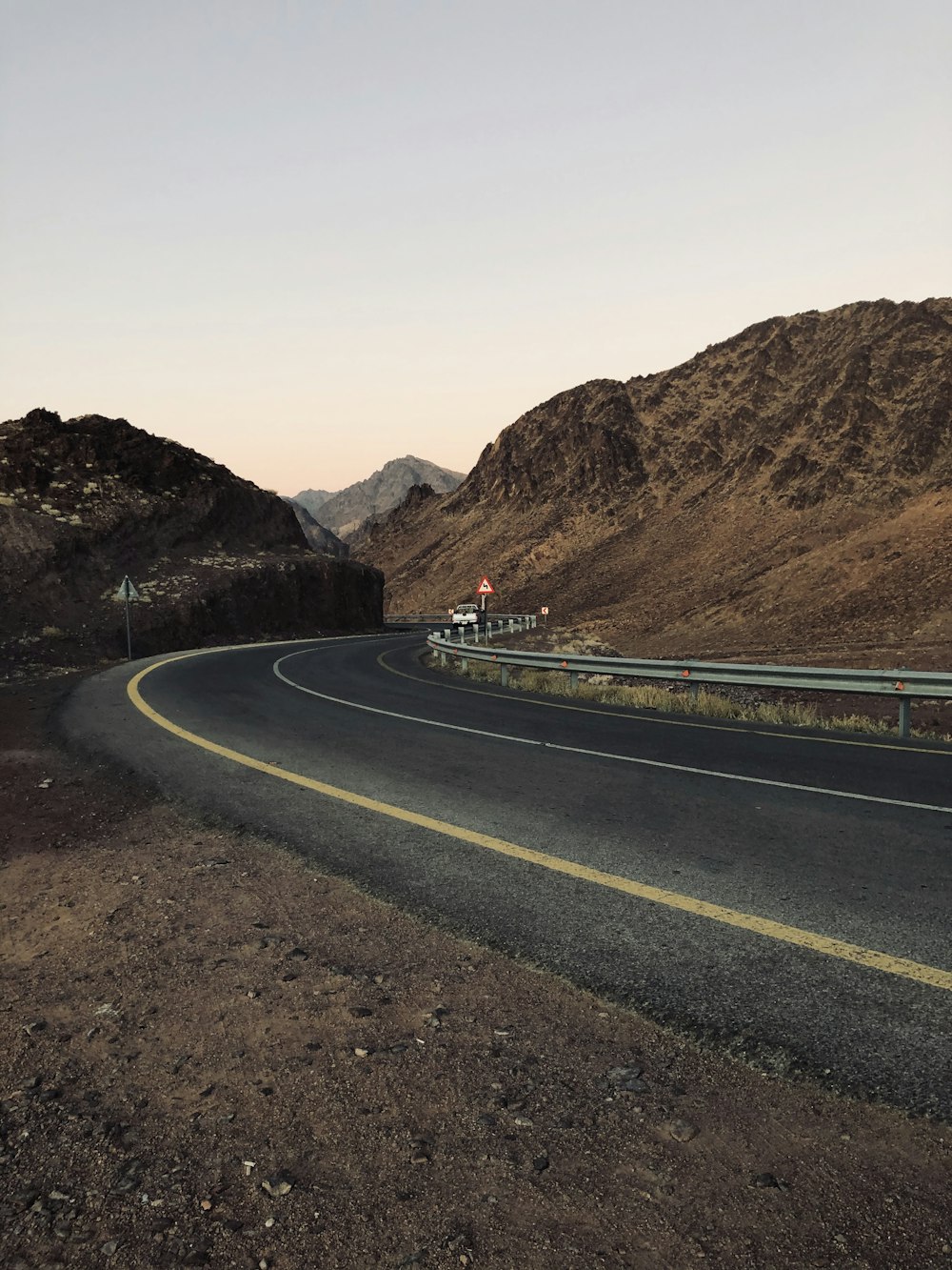 estrada de asfalto preto perto da montanha marrom durante o dia