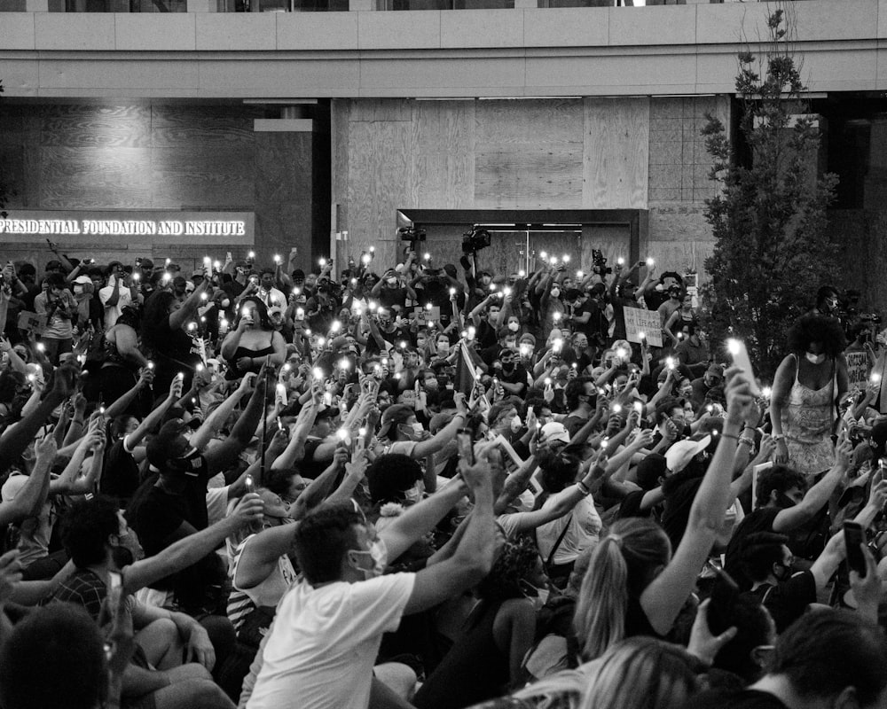 foto em tons de cinza de pessoas na frente do prédio