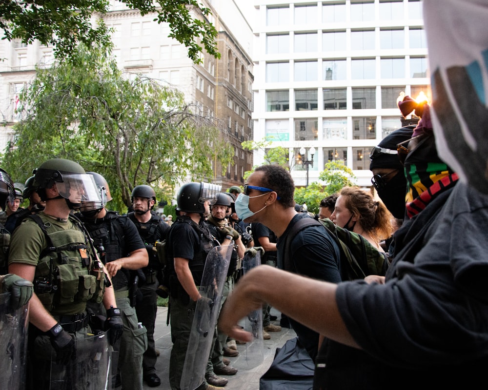 people in black uniform standing on street during daytime