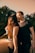 man in black crew neck t-shirt kissing woman in black sleeveless dress during daytime