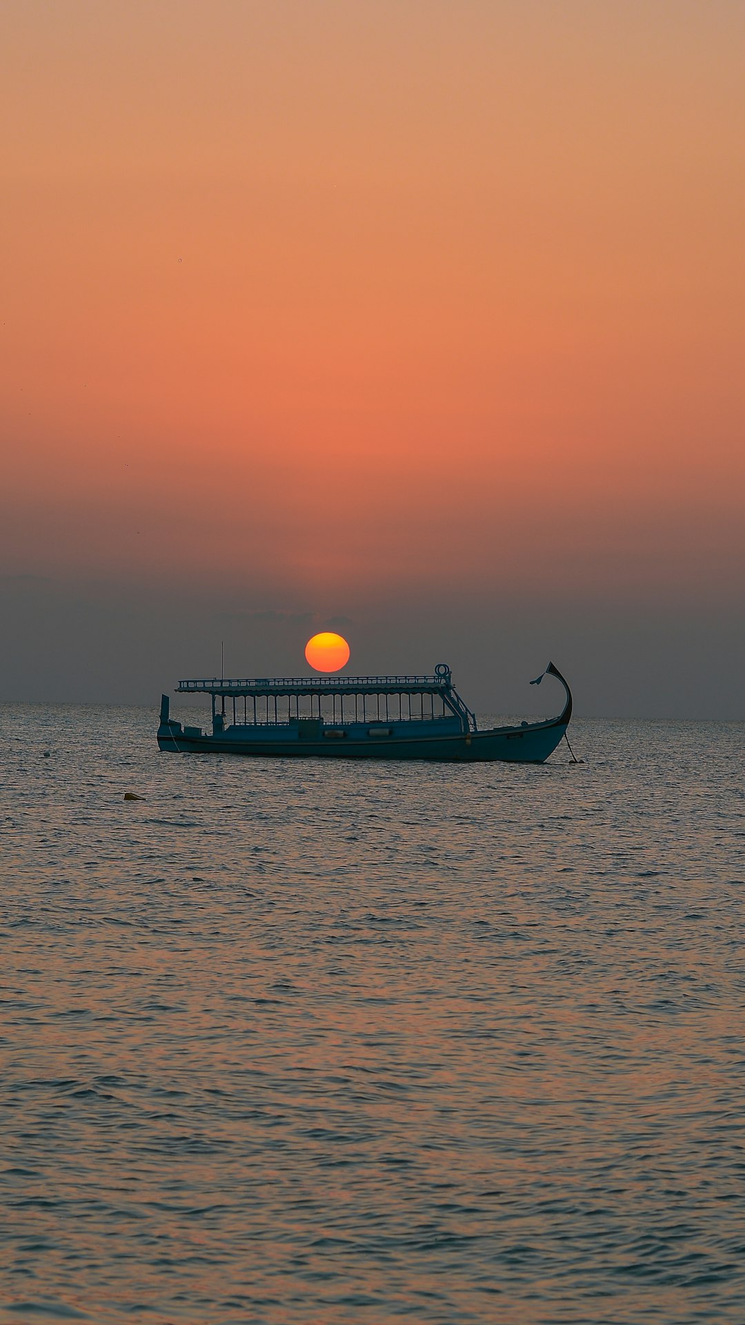 silhouette of boat on sea during sunset