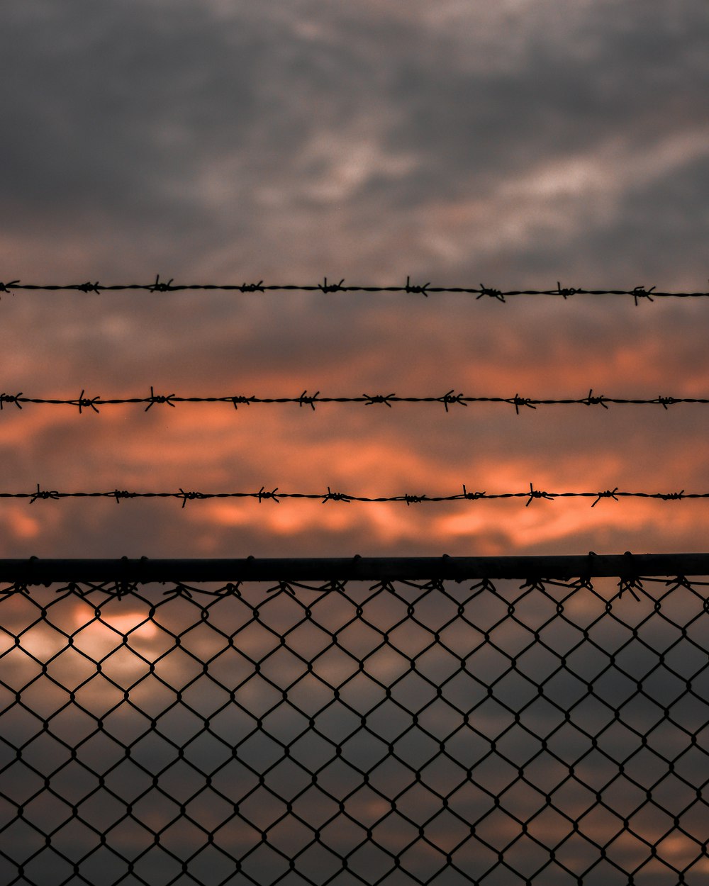 recinzione metallica grigia sotto nuvole grigie