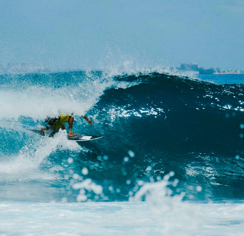 man surfing on sea waves during daytime