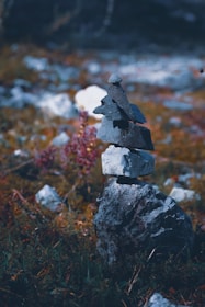 A calm rock cairn balanced on a smooth stone surface in natural earth tones.