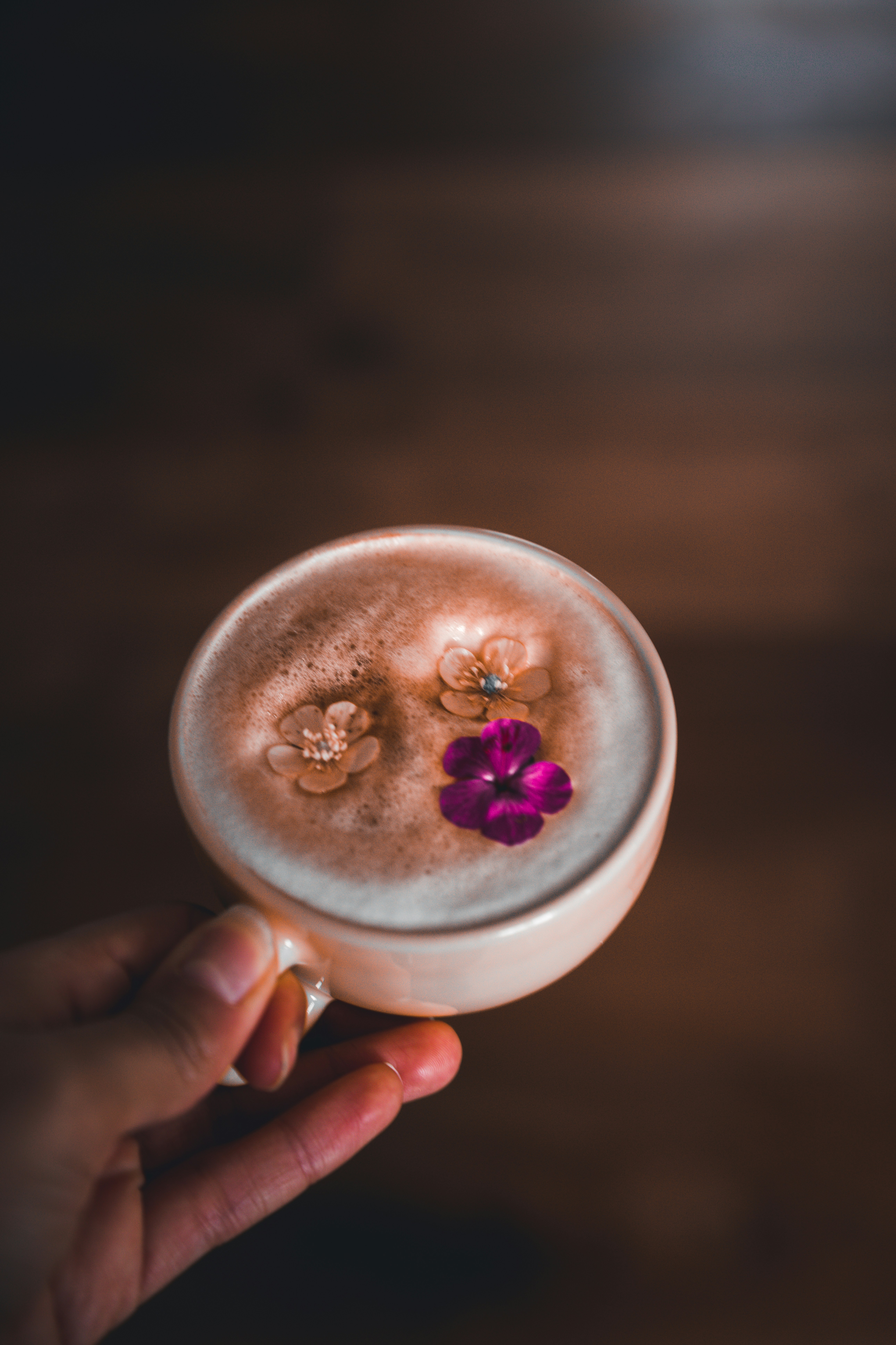person holding white ceramic mug with brown liquid