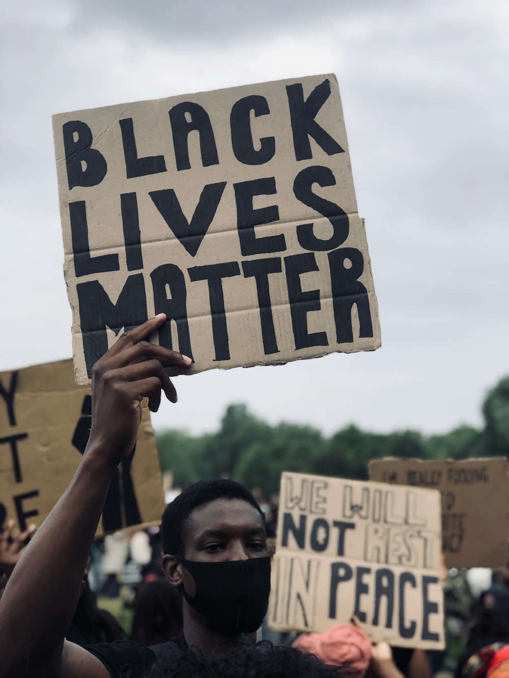 person holding white and black welcome to the beach signage