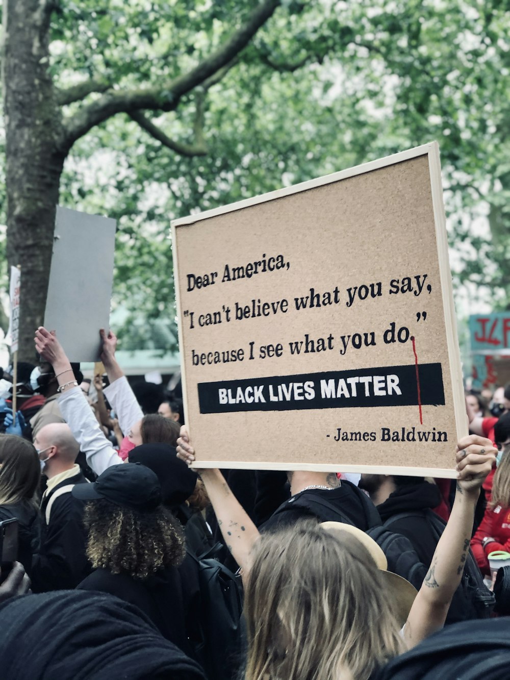 people holding brown and black quote board during daytime
