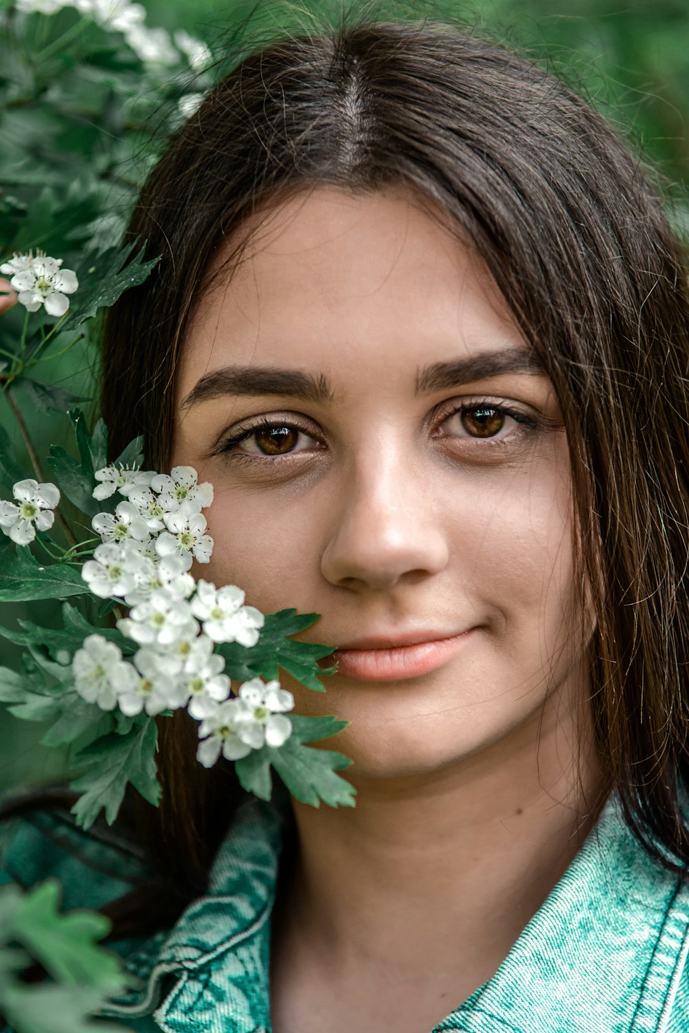 woman with brown hair with white flowers on her ear