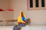 woman in yellow hijab sitting on white wooden table