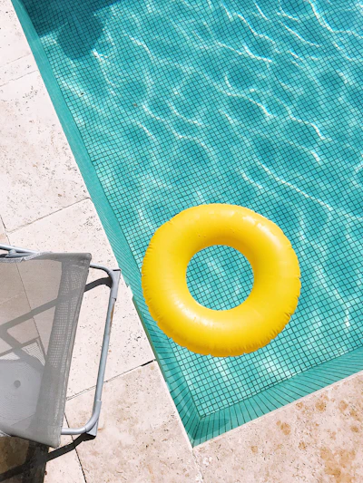 yellow pool float on swimming pool edge