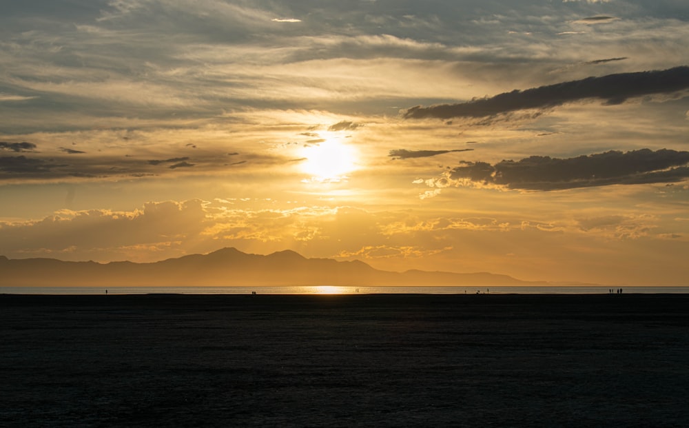 body of water under cloudy sky during sunset