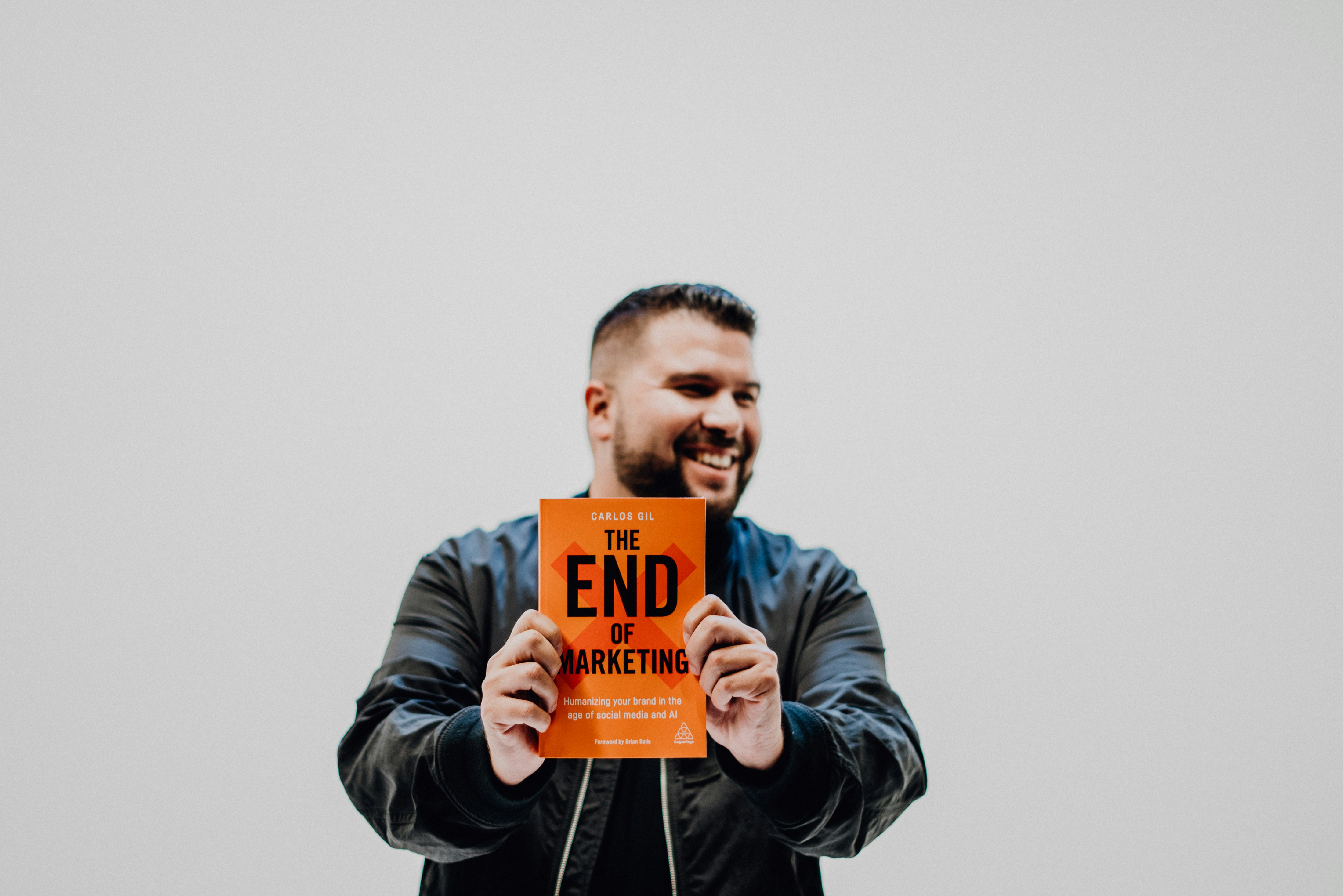 man in black jacket holding orange and white box