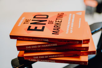 a stack of orange books sitting on top of a chair