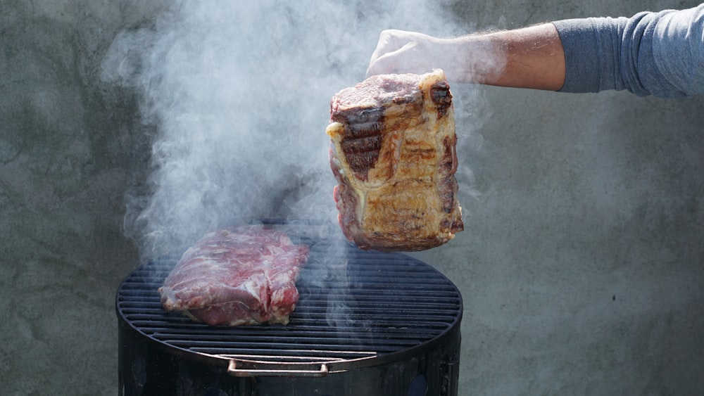 person holding a grilled meat