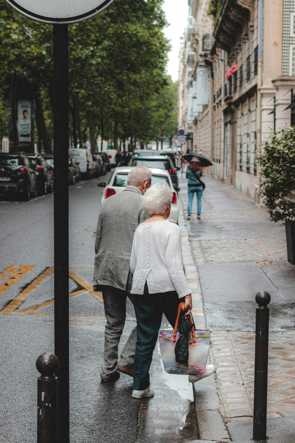 man in white dress shirt and black pants walking on sidewalk during daytime