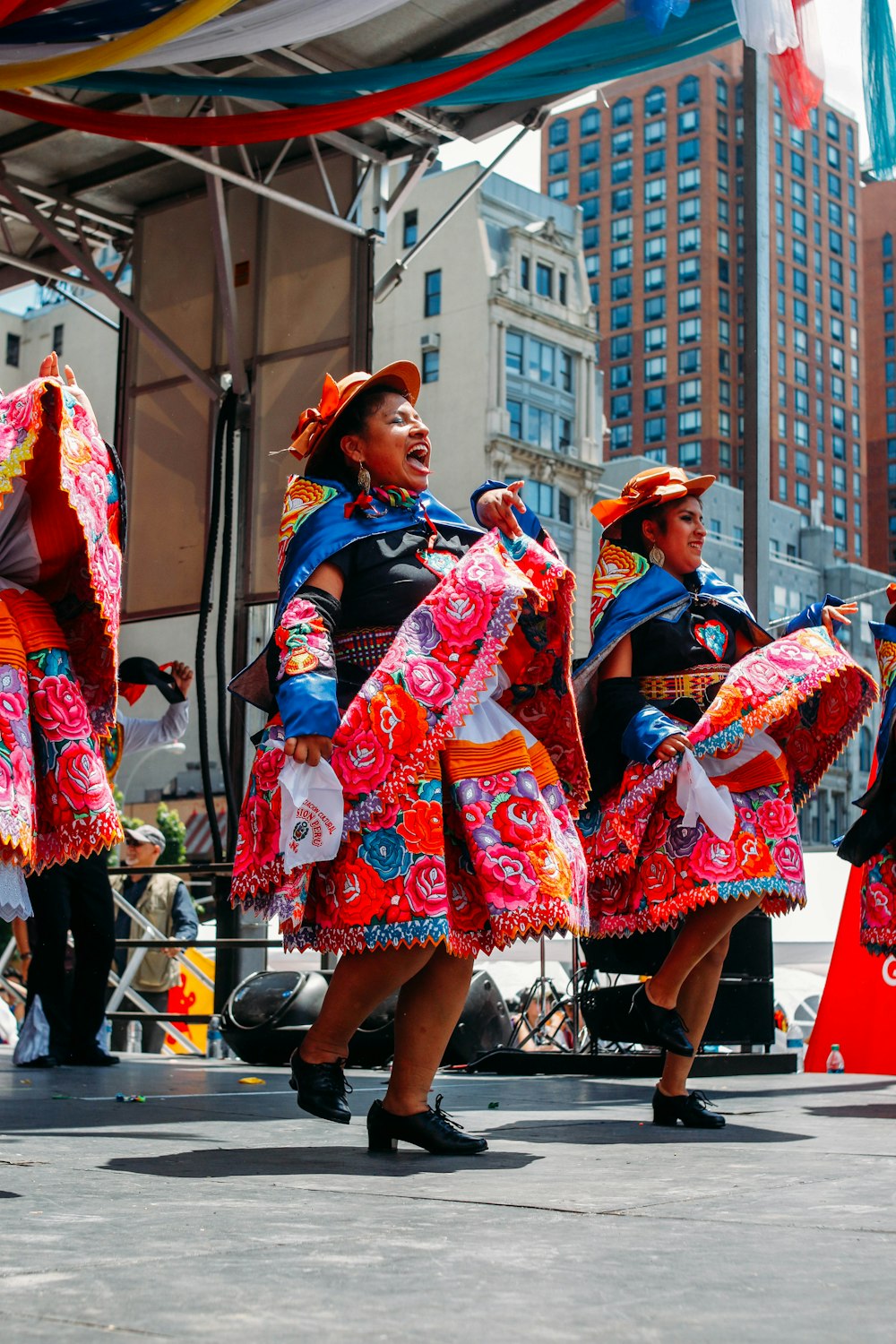 woman in blue and red floral dress wearing black hat standing on street during daytime