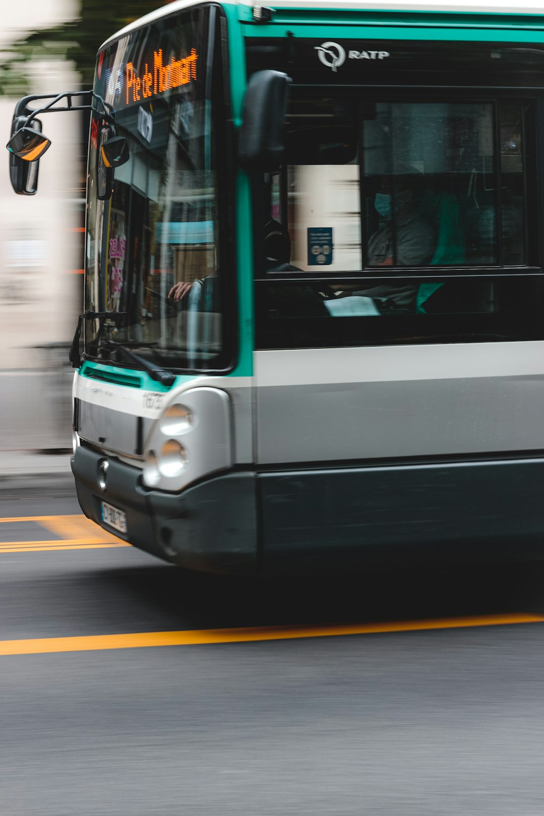 white and green bus on road during daytime