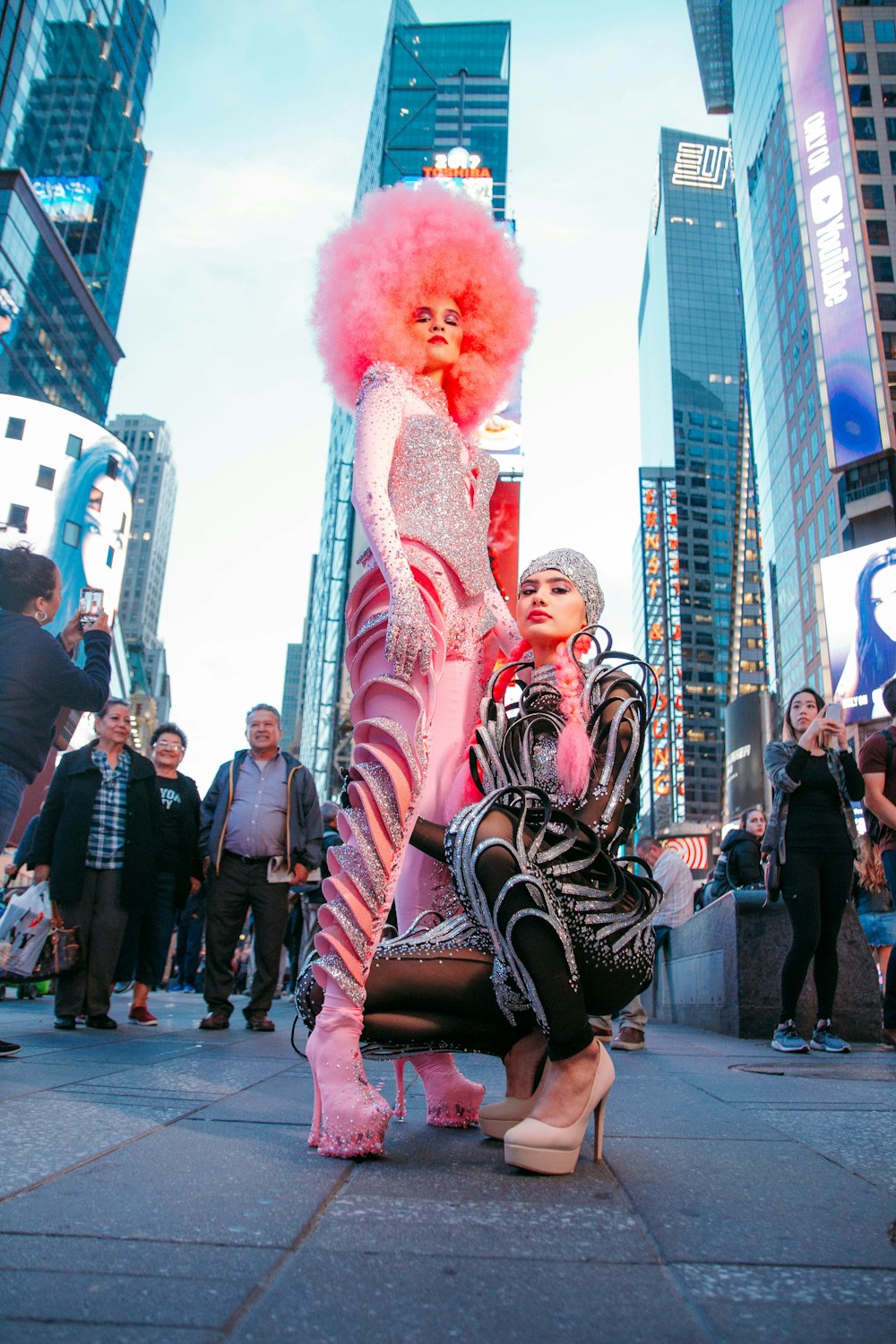 man in red wig and black and white striped long sleeve shirt standing on street during