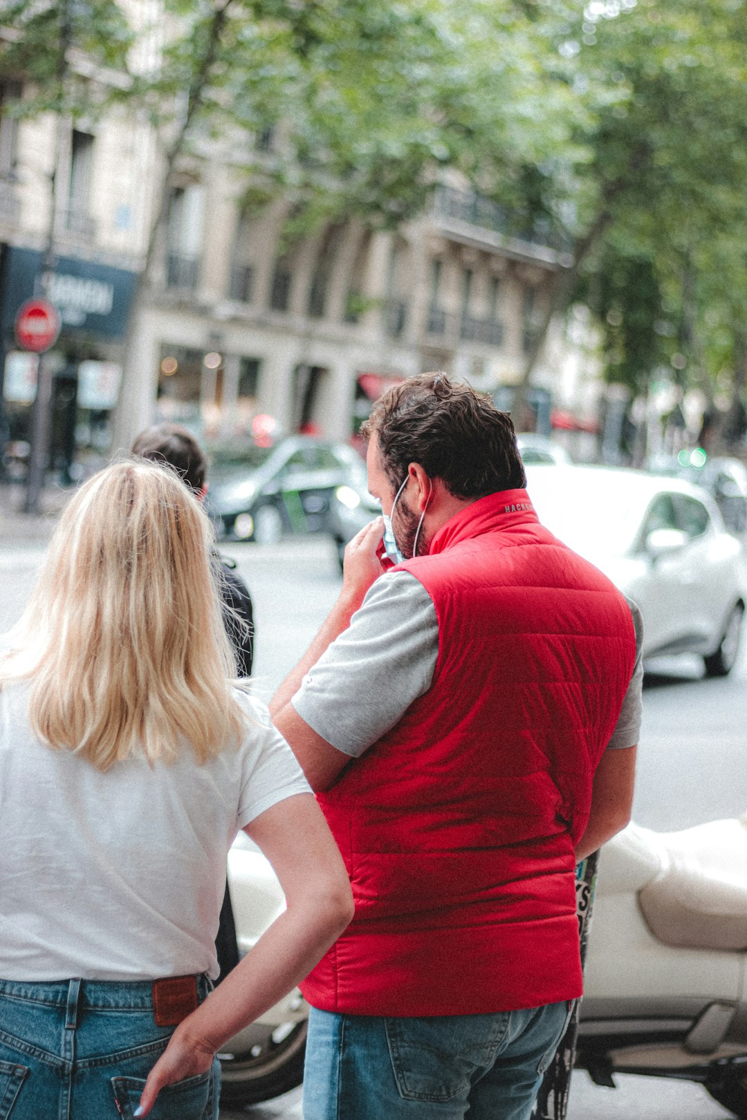 man in red shirt kissing woman in white shirt