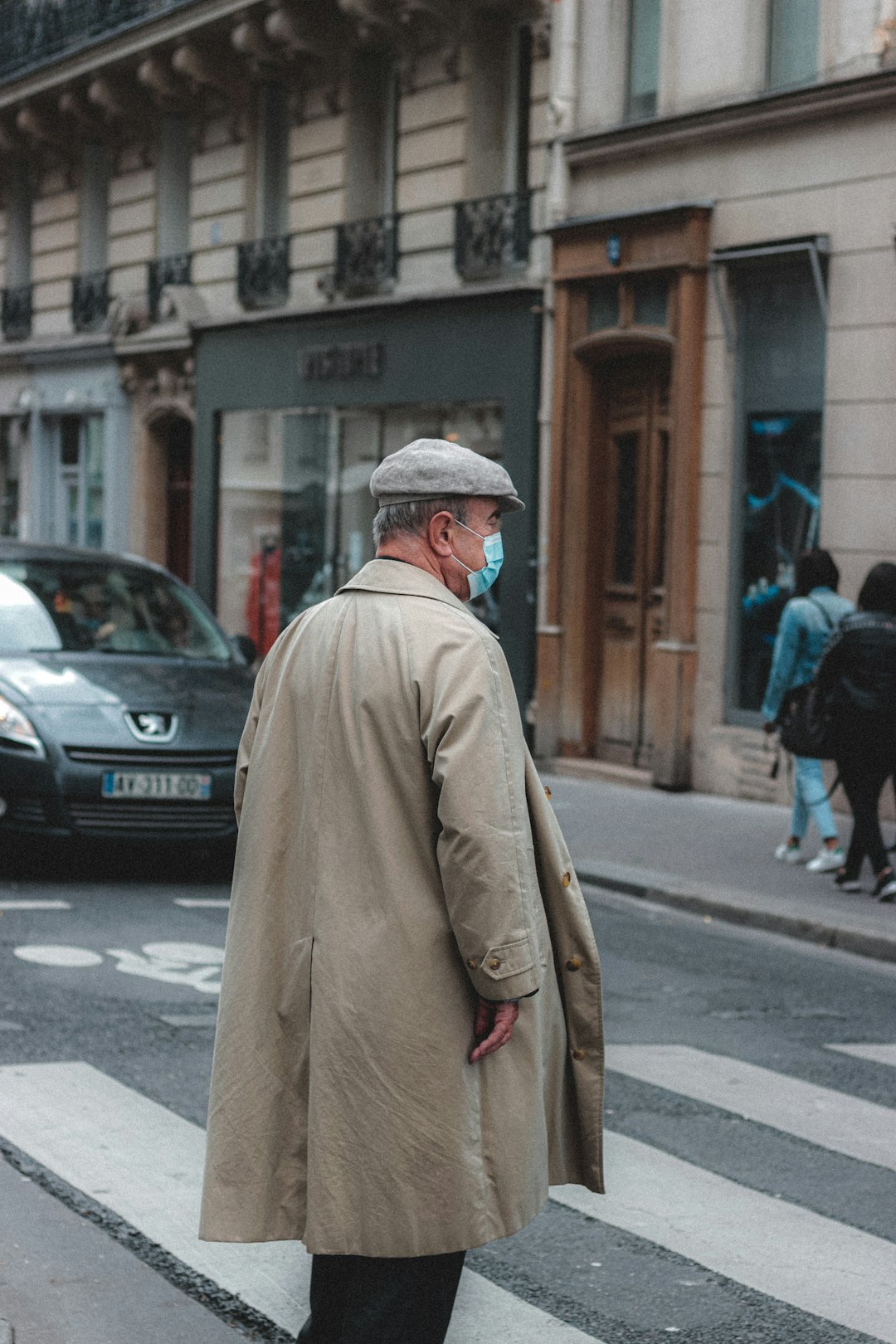 man in brown coat walking on street during daytime