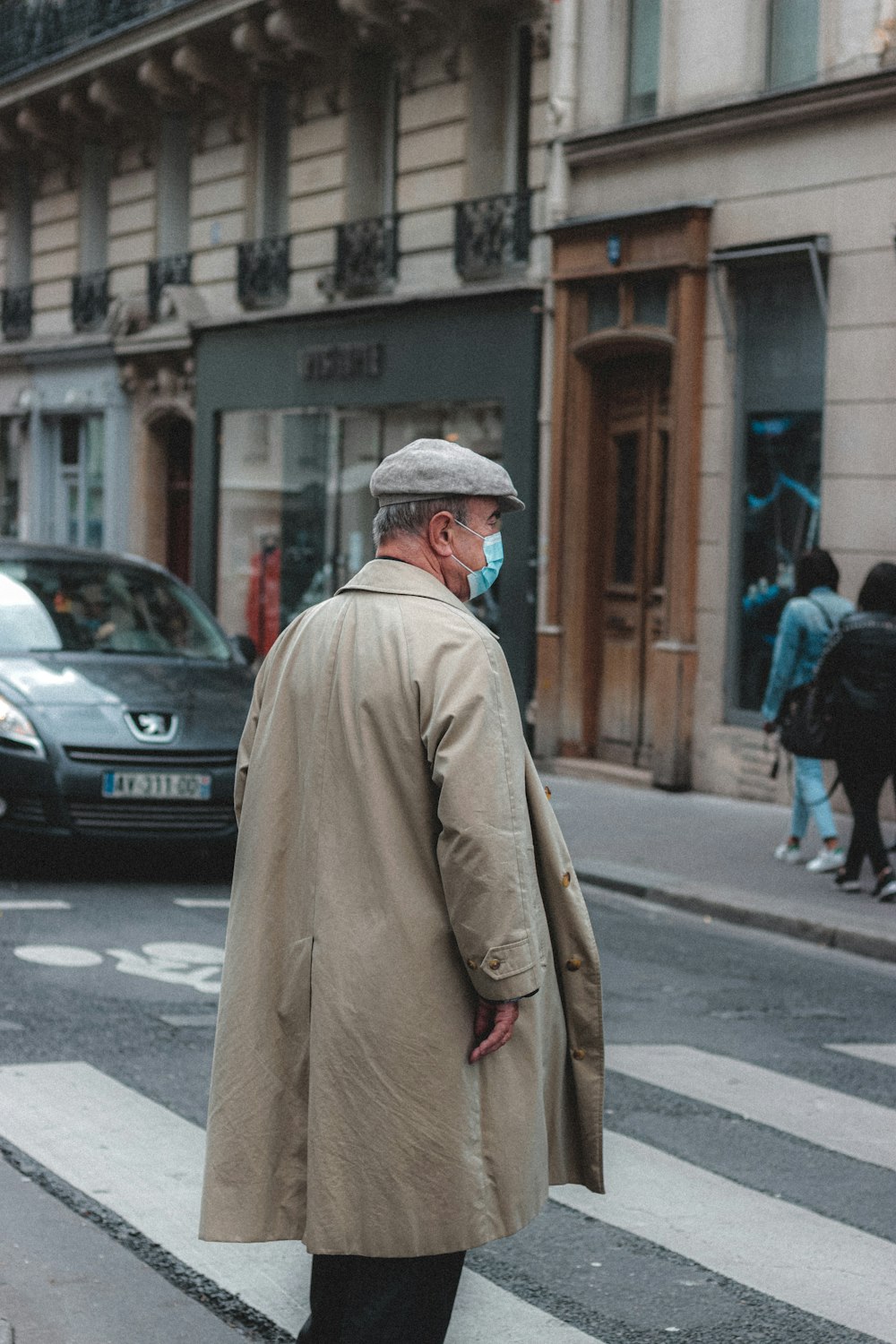 man in brown coat walking on street during daytime