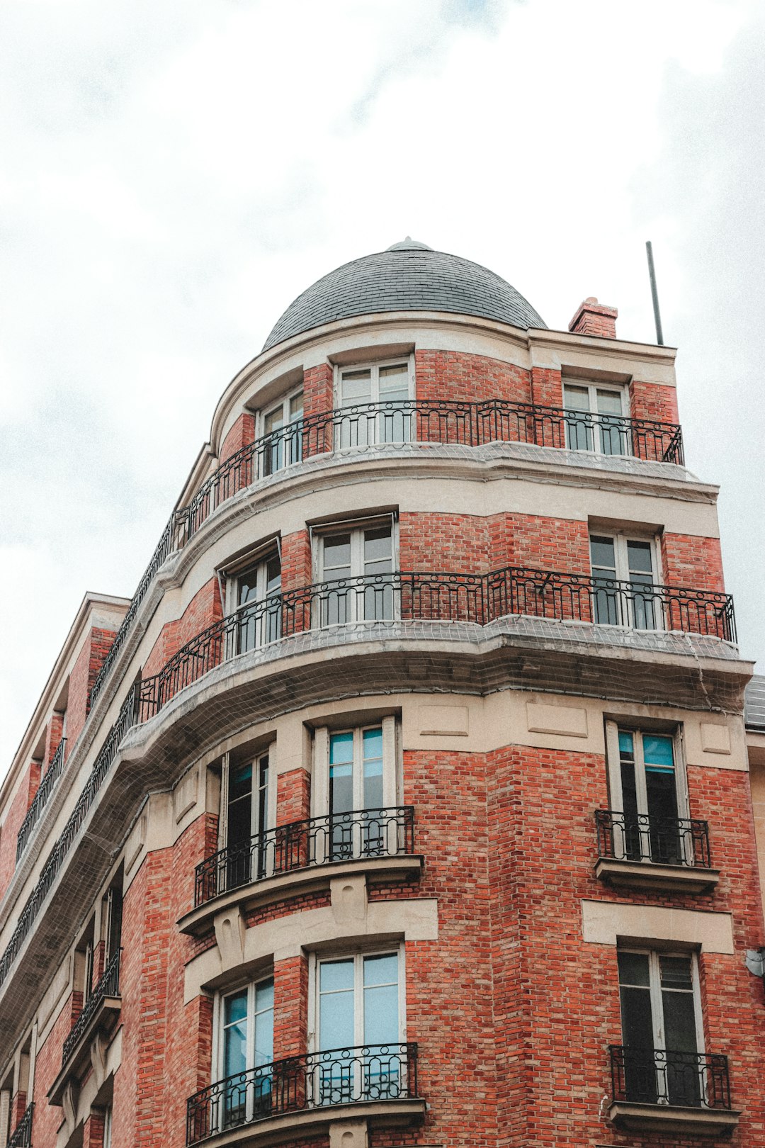 brown brick building under white clouds during daytime