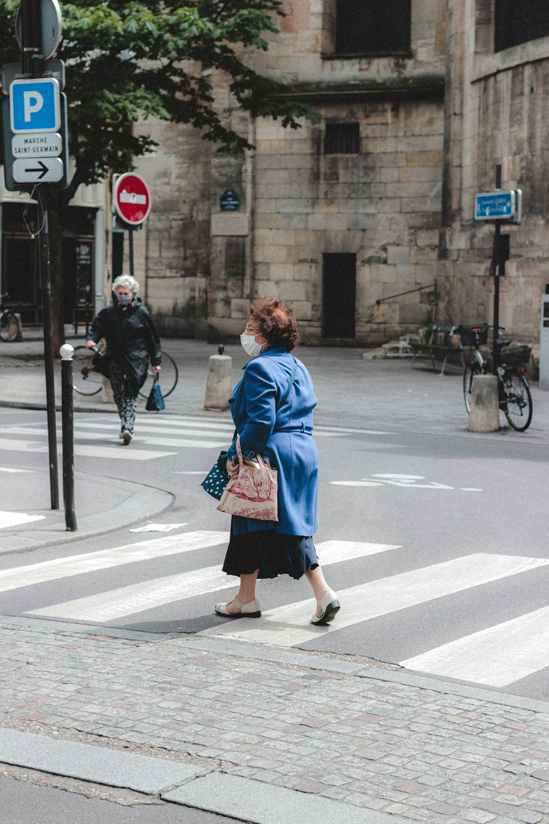 woman in red robe standing on sidewalk during daytime