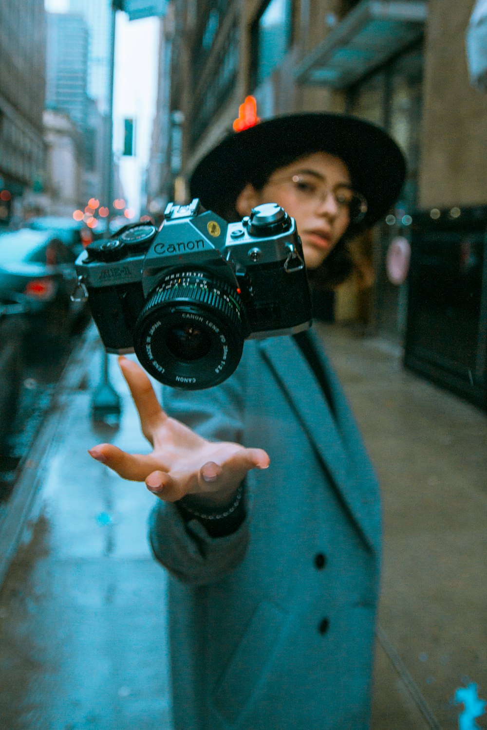 man in blue jacket holding black nikon dslr camera