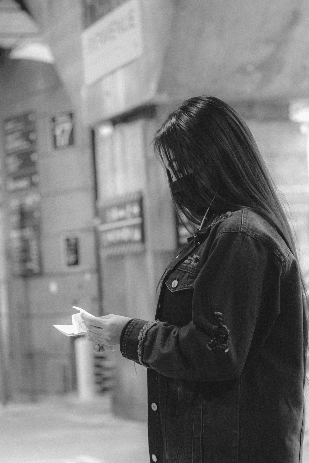 woman in black jacket holding white smartphone