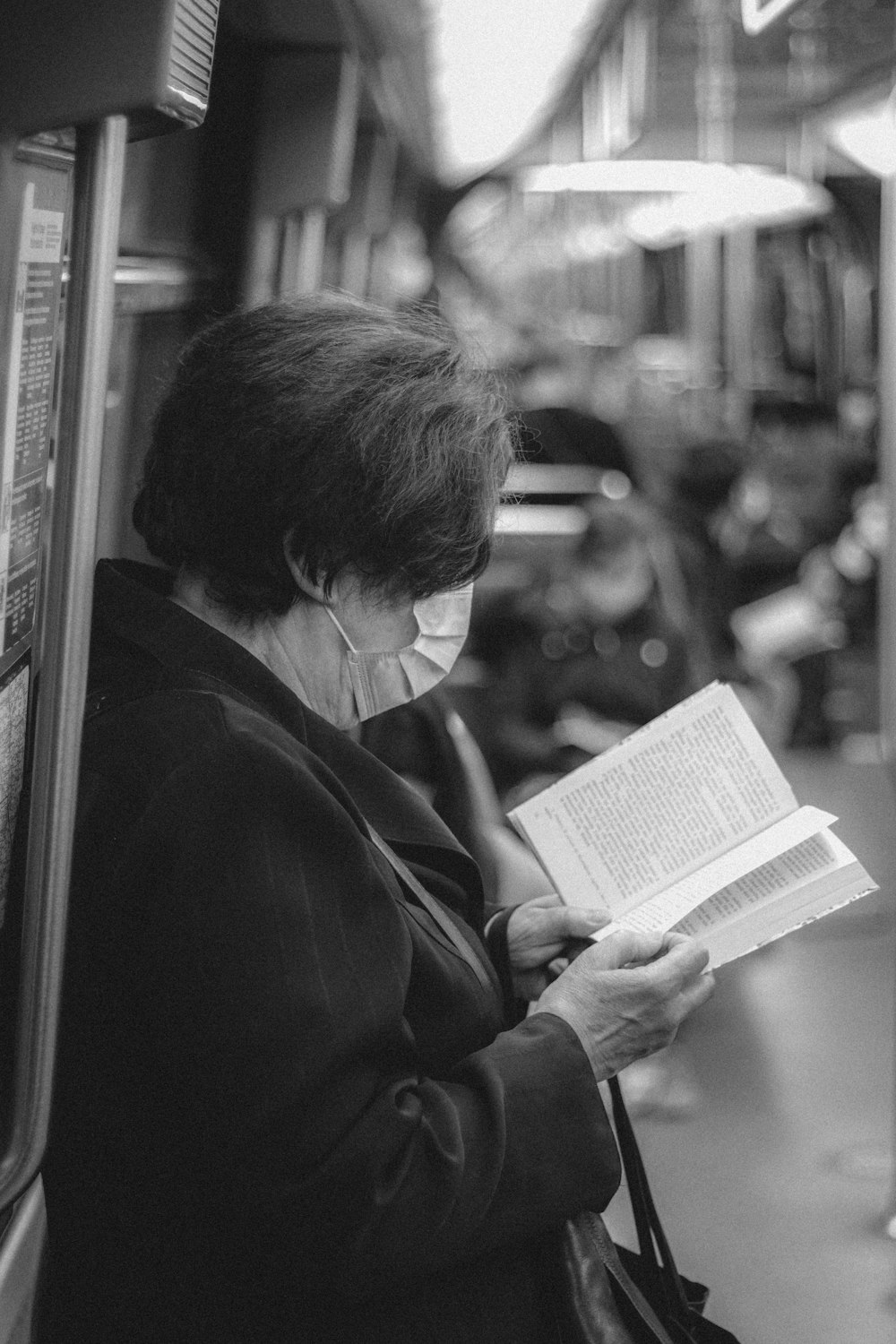 grayscale photo of man reading book