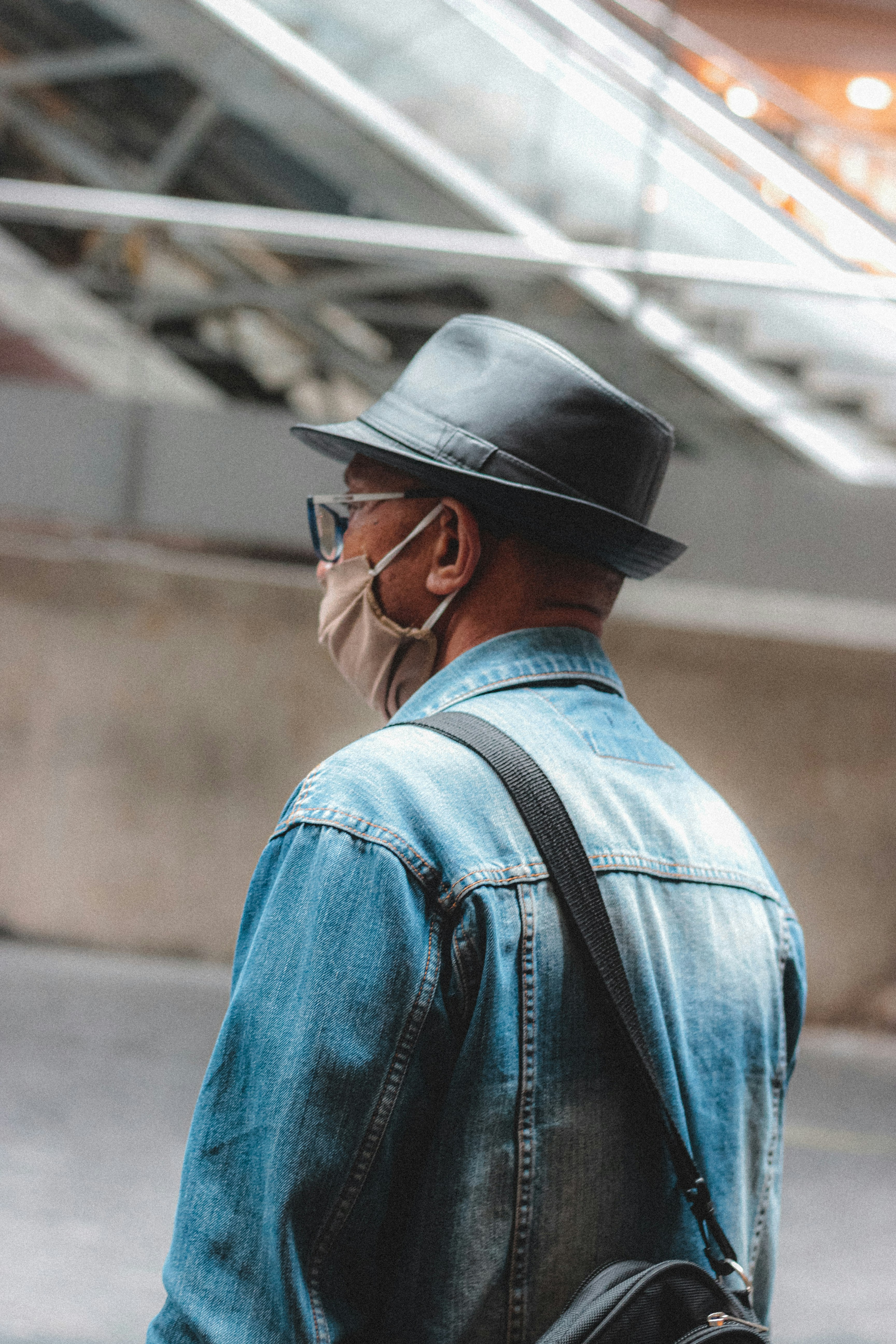 man in blue denim jacket wearing black fedora hat