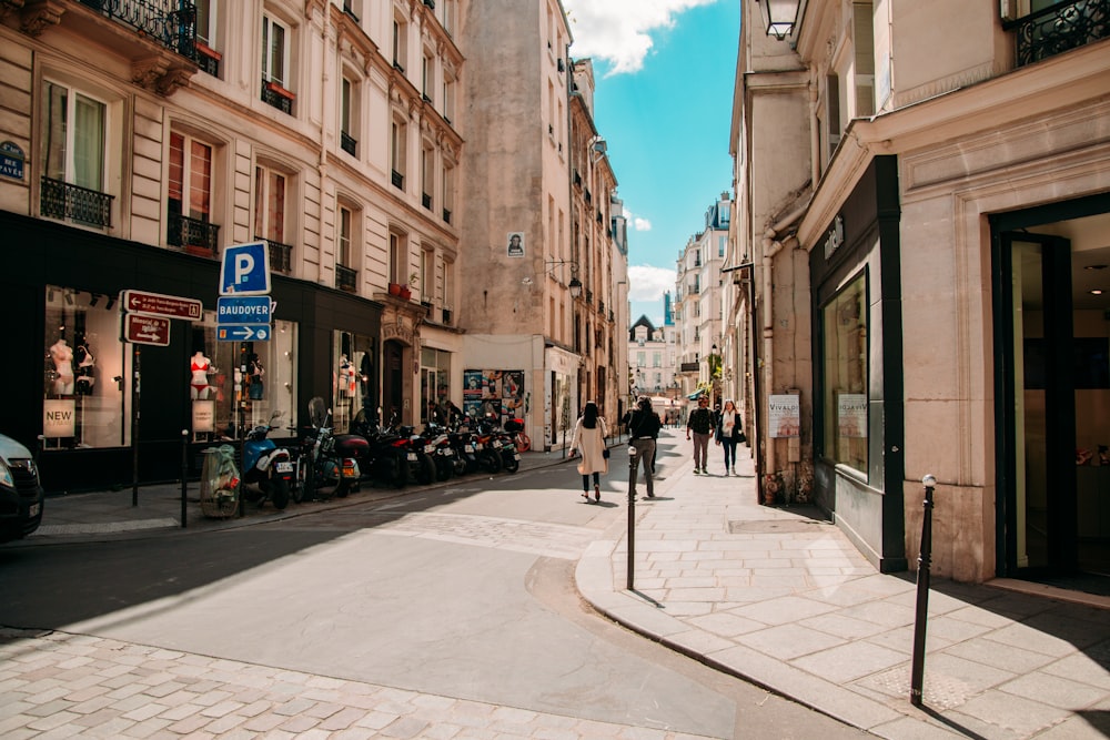 people walking on sidewalk near buildings during daytime