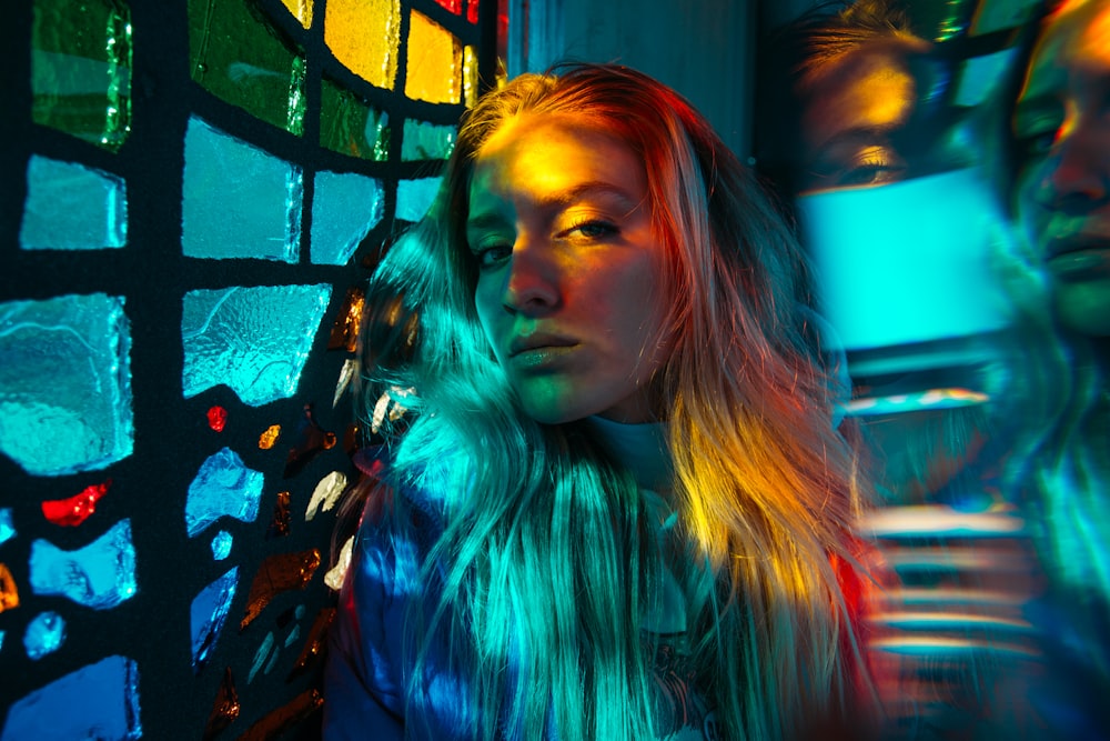 woman in blue and black long sleeve shirt standing beside wall with graffiti