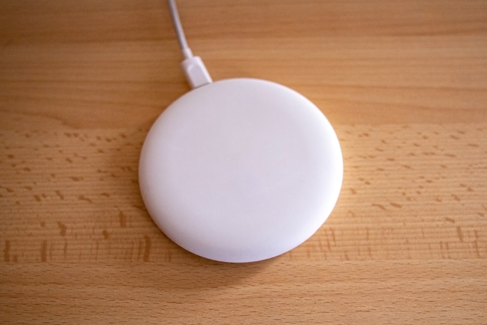 Dispositivo redondo blanco sobre mesa de madera marrón