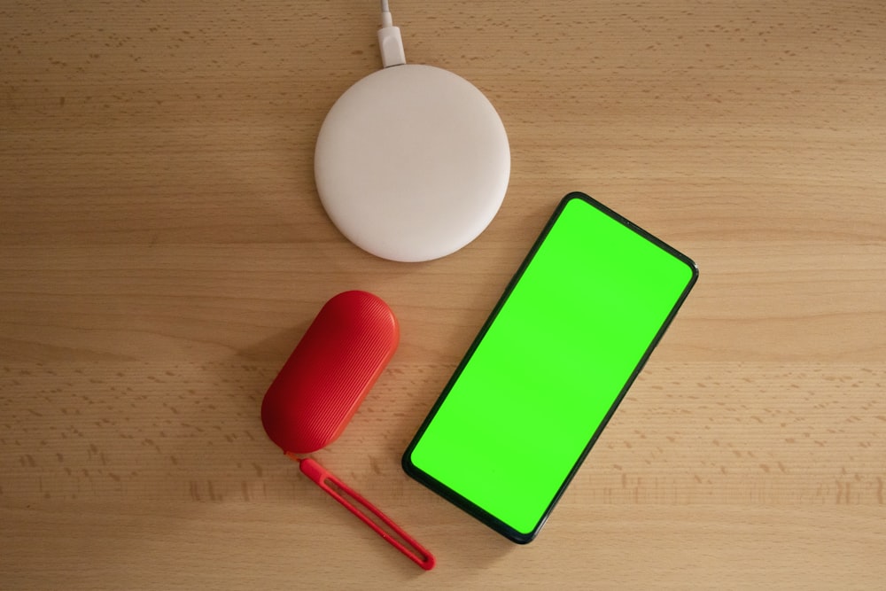 Funda verde y blanca para iPhone sobre mesa de madera marrón