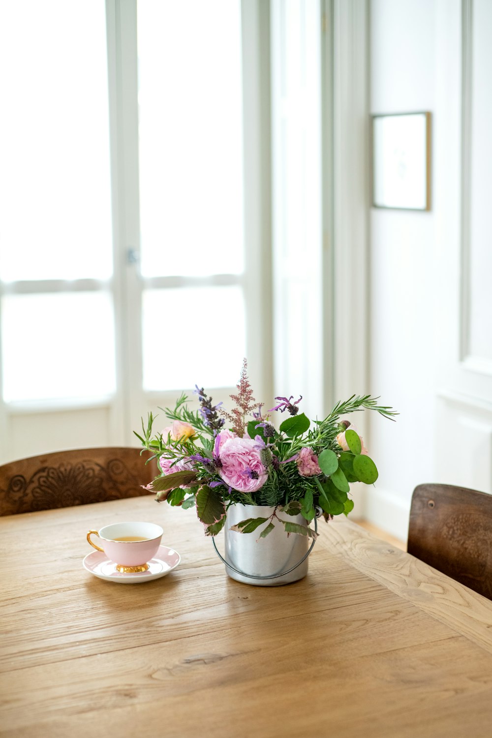 uma mesa de madeira coberta com um vaso cheio de flores
