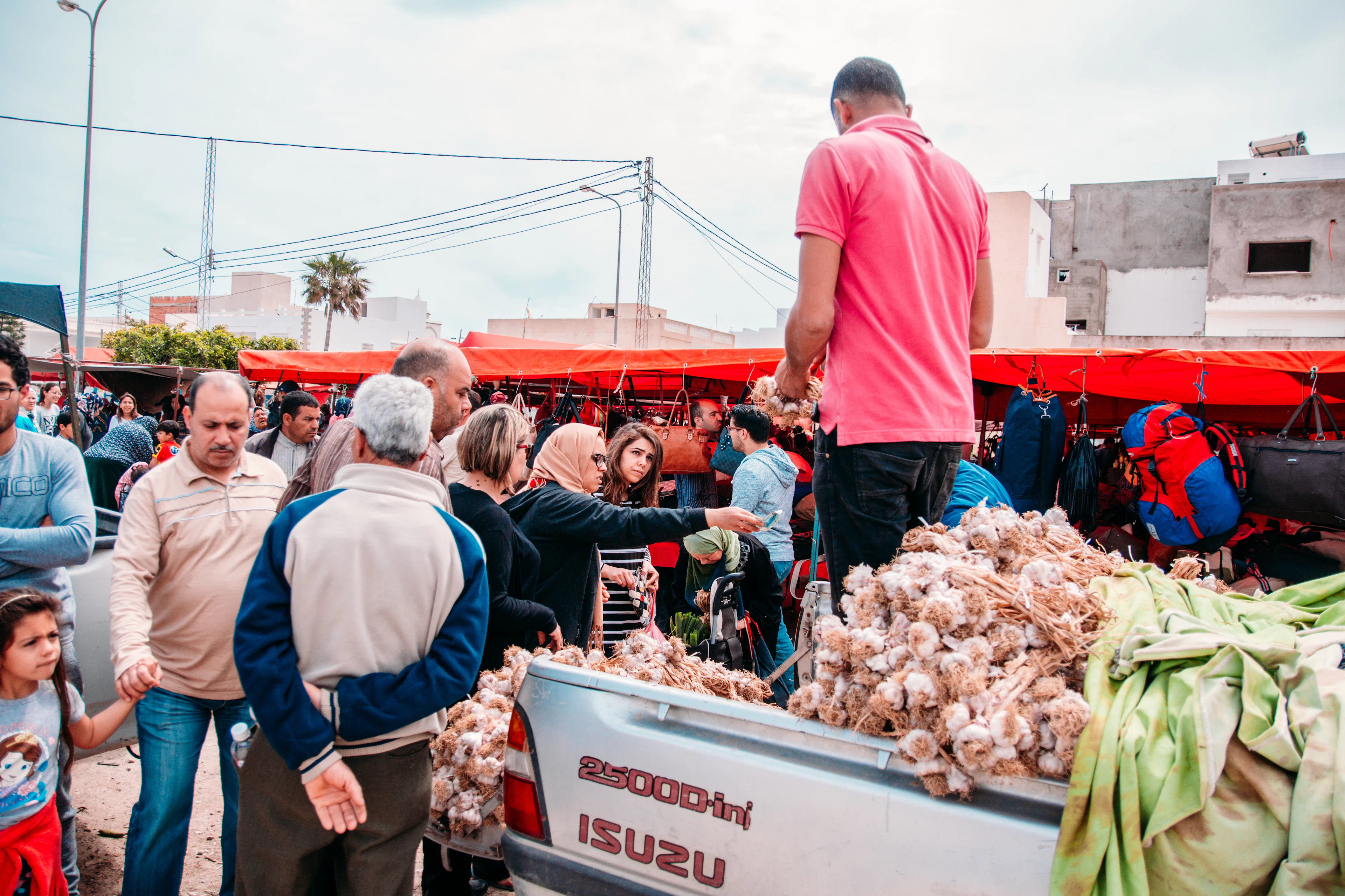 A crowded market in Tunis, garlic piled on the stall in front