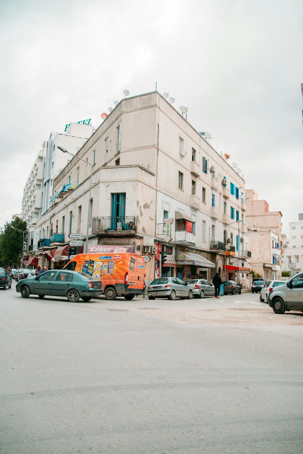 cars parked beside white concrete building during daytime