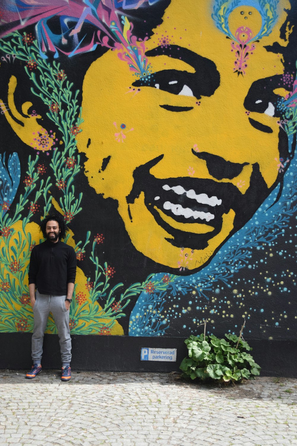 man in black crew neck t-shirt standing beside yellow and black wall with yellow and