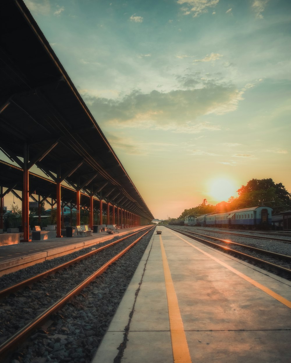 train rail under cloudy sky during sunset